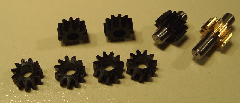 S1050427b.JPG - The top gear of the gearbox (brass), the idler (delrin), and six axle gears (this the set for the red 3-tr Shay, the set for the 2-tr Shay contains two axle gears less)